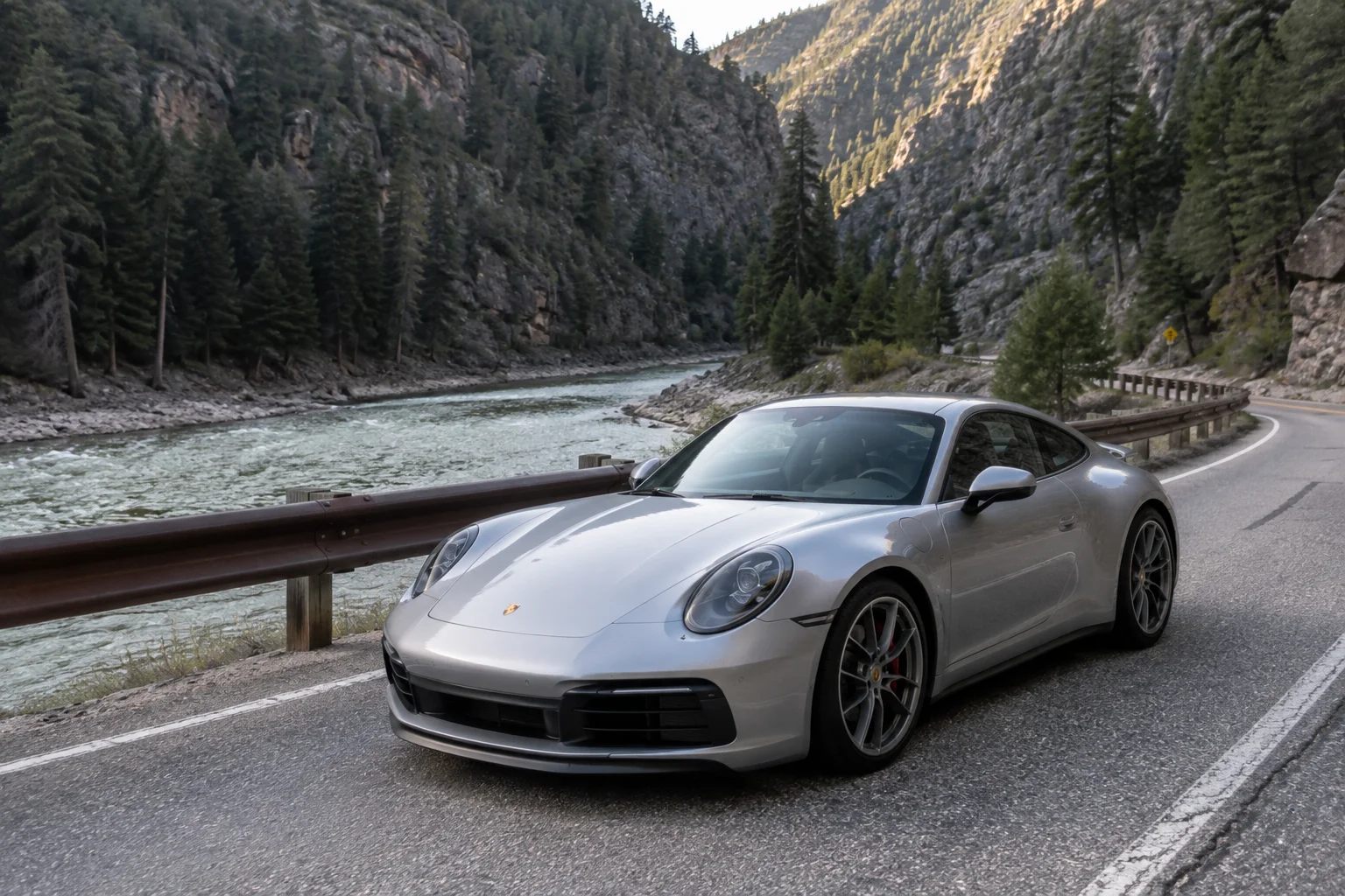 Silver Porsche 911 on a winding forest highway along the Payette River near Boise, Idaho